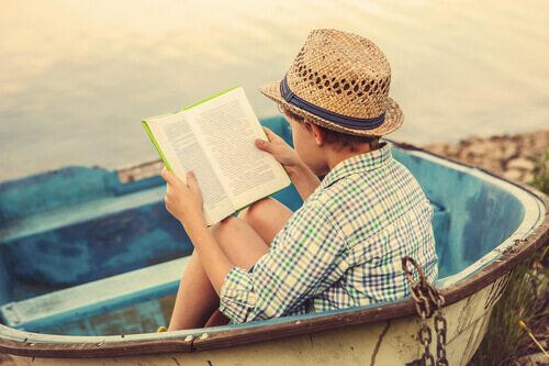 Niño leyendo en la playa