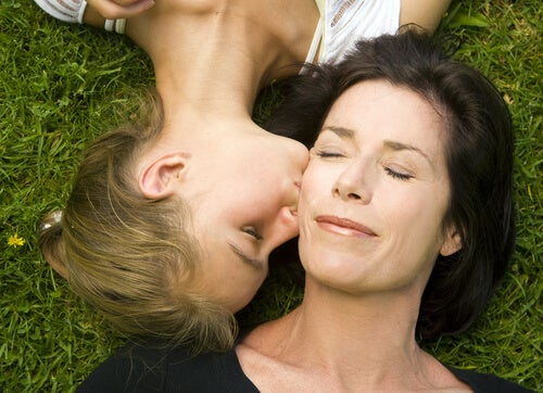 Hija adolescente dándole un beso a su madre en la cara