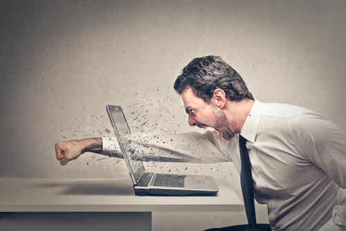 Hombre con agresividad golpeando ordenador
