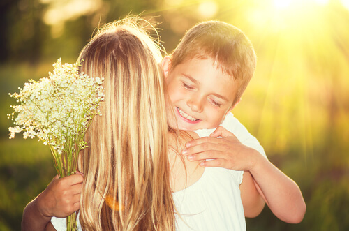 Madre abrazando a su hijo con ramo de flores