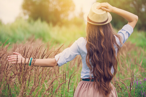 Femme au chapeau marchant sur le sentier