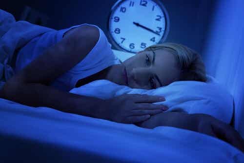 Mujer en la cama debido a la apnea del sueño en la mujer