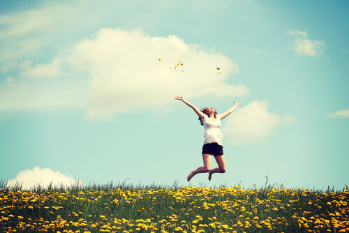 Mujer feliz en el campo saltando