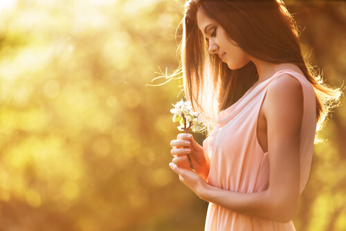 Vrouw kijkt naar bloemen