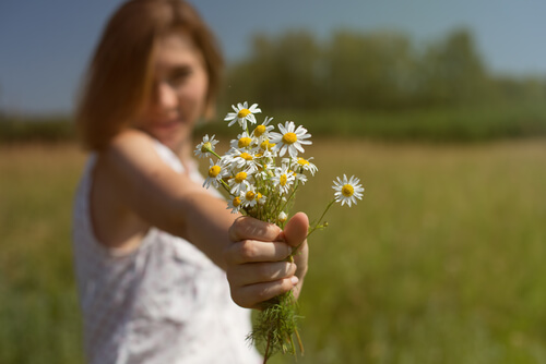 Mujer complaciente ofreciendo flores