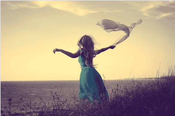Mujer sola mirando el horizonte con un pañuelo en la mano