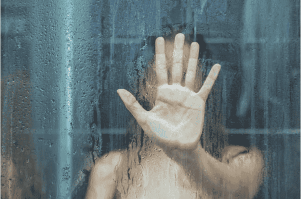 Mujer sola detrás de la ventana duchandose