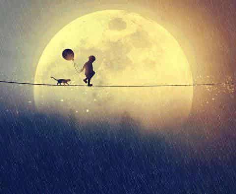Niño caminando con su gato y un globo cerca de la luna