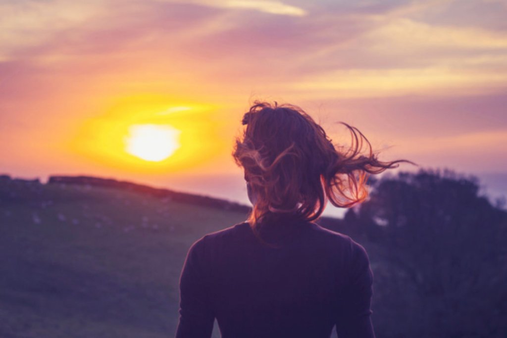 Mujer mirando el sol ponerse
