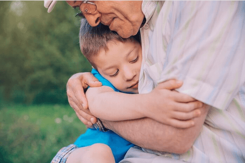 Niño recibiendo abrazos de su abuelo