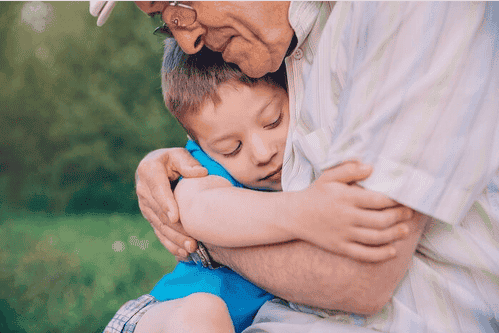 Niño recibiendo abrazos de su abuelo