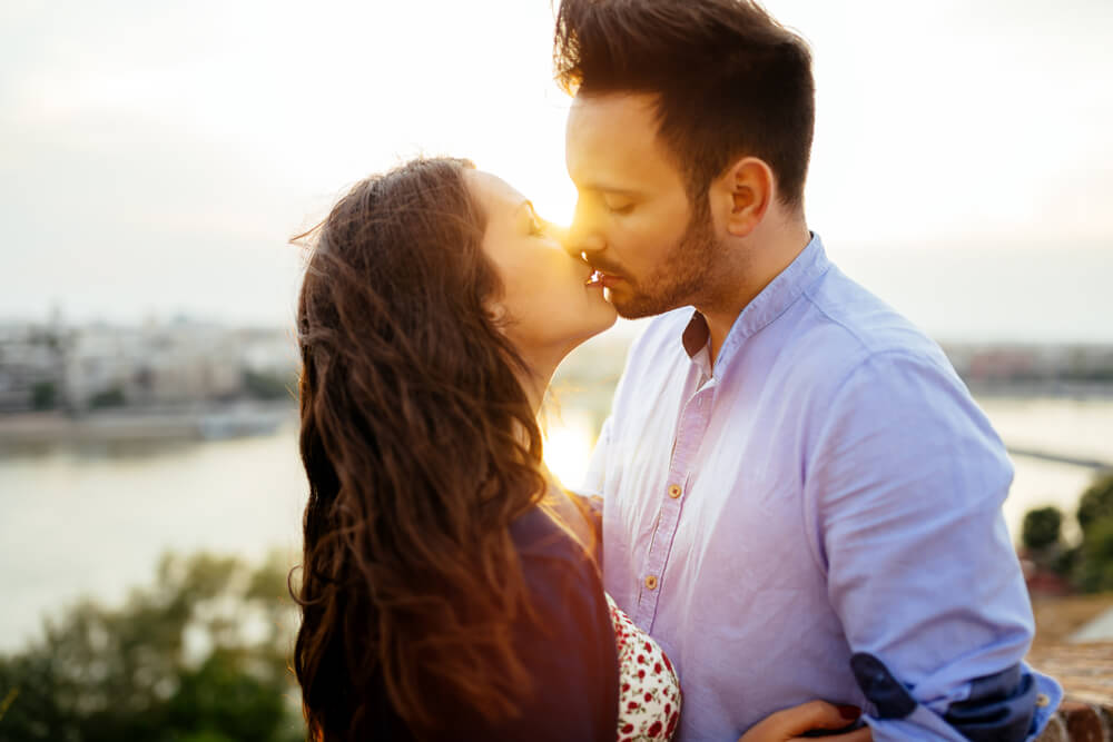 Pareja dándose un beso representando ser más románticos