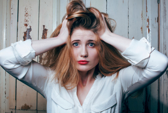 Vrouw met haar handen in haar haar