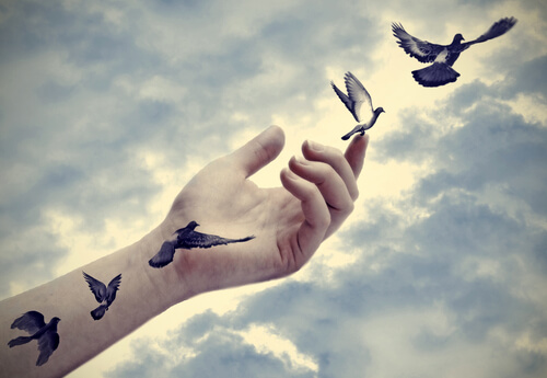 Mano con pájaros volando
