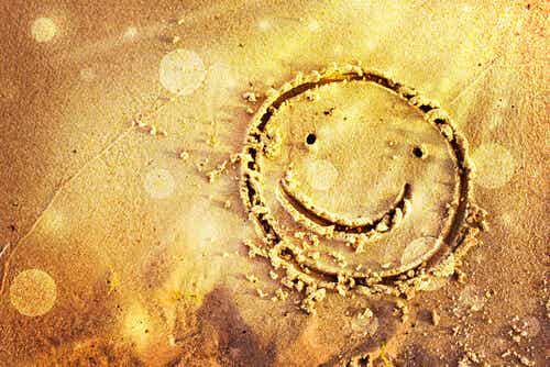 Cara dibujada en la arena feliz de su buena suerte