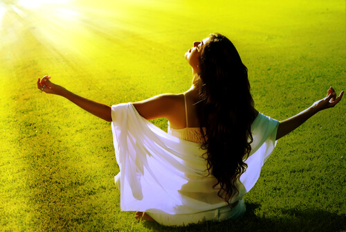 Mujer meditando al amanecer