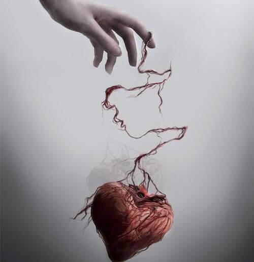 Mano sujetando corazón maltratado