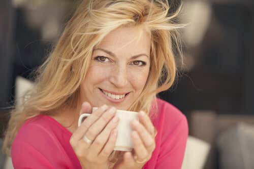 Mujer de cuarenta tomando café simbolizando cómo ser más felices después de la mediana edad