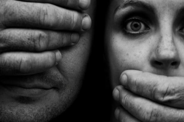 Hombre cubriéndose los ojos y mujer tapándose la boca