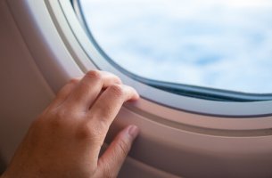 Mano en la ventana del avion