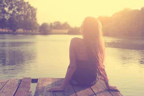 Mujer pensando sentada en un lago