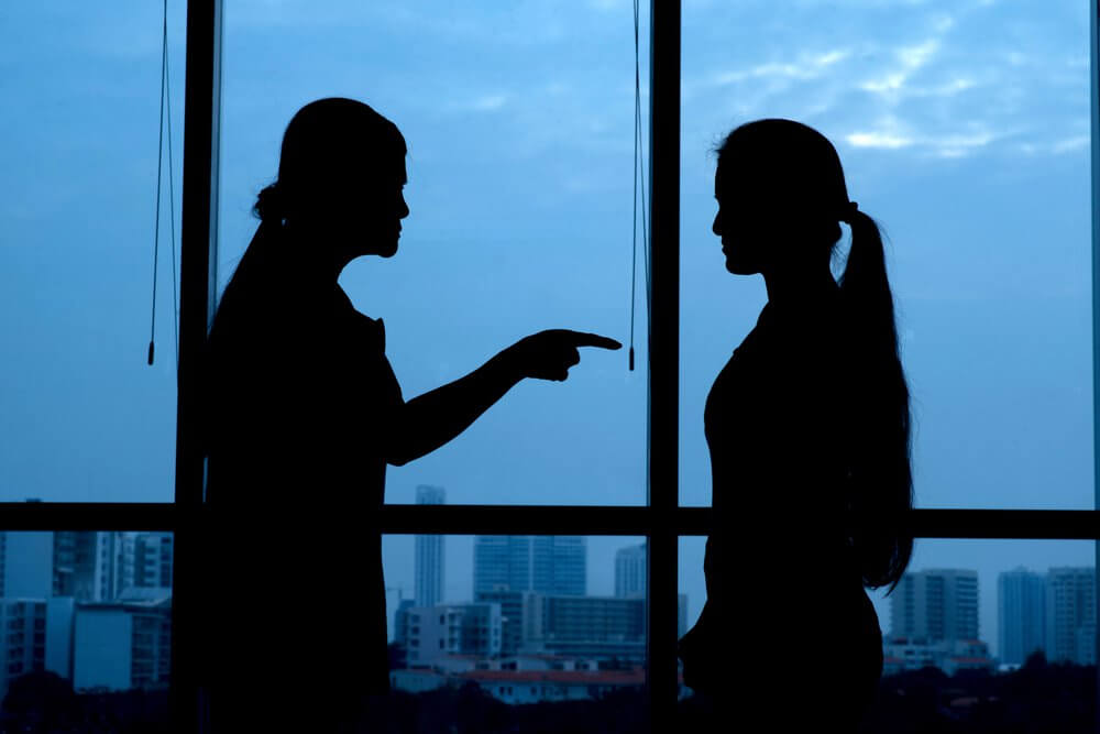 Mujer señalando con el dedo a otra echándole la culpa