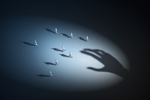 Sombra de una mano que persigue a personas