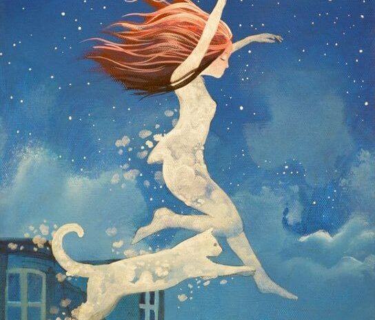 Chica saltando feliz con gato