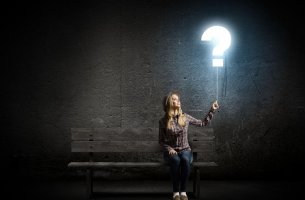 Mujer sujetando una interrogación pensando