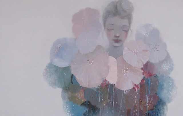 mujer en fondo gris rodeada de flores