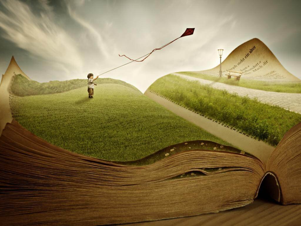 Niño aprendiendo a pensar en un libro y con una cometa