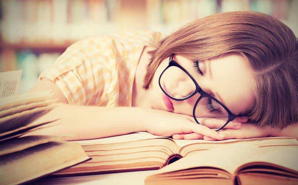 Sliten kvinne sover på en bok