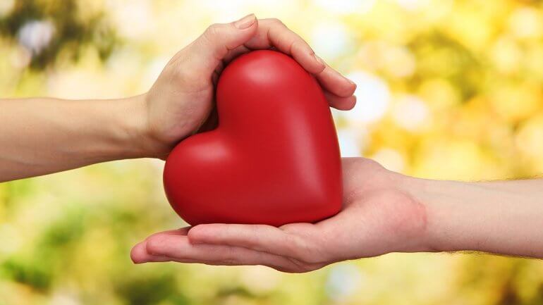 Mains de deux personnes tenant un coeur