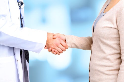 Médico y paciente dándose la mano