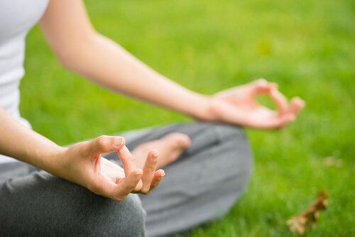 Mujer-sentada-meditando-con-las-manos-apoyadas-en-las-rodillas