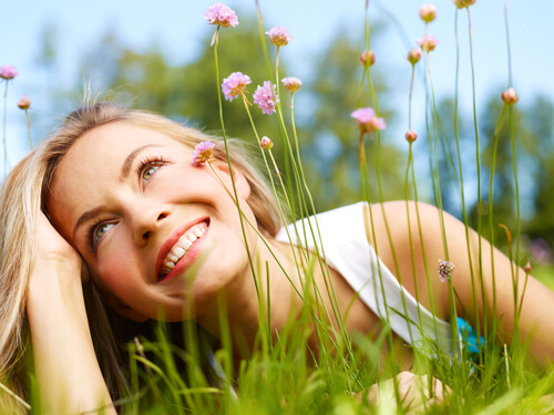 Mujer sonriendo entre flores