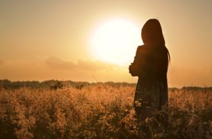 Mujer triste observando el atardecer