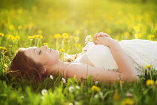 Mujer tumbada en el campo pensando en sus sueños