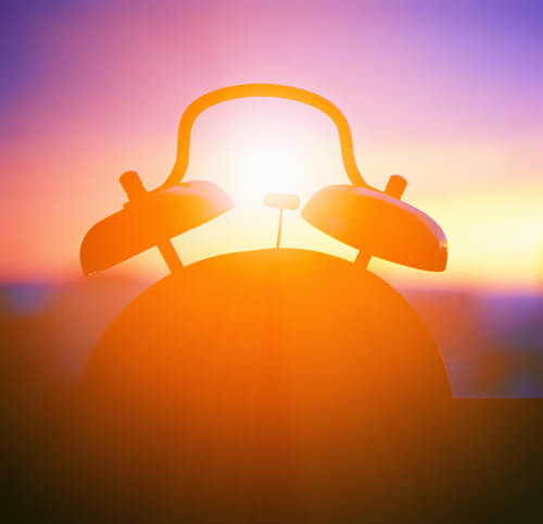 Clock in a window at sunrise