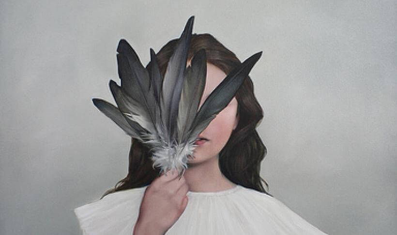 fille couvrant son visage de plumes