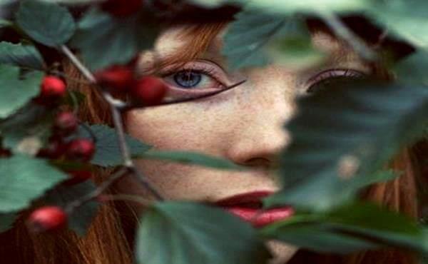 Joven escondida en una enredadera