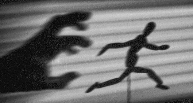 La sombra de una mano atrapando a un muñeco