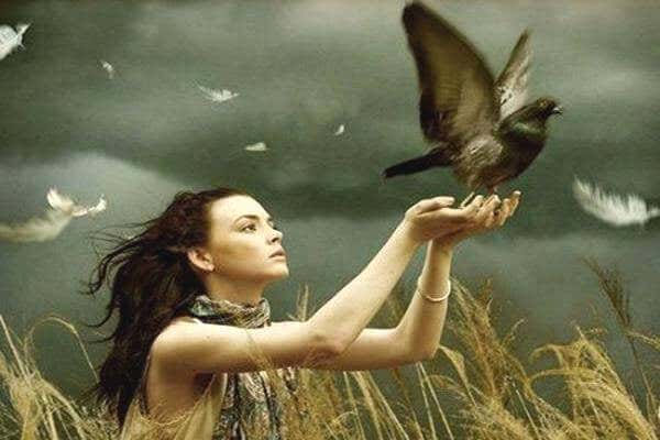 Mujer liberando una paloma de sus manos