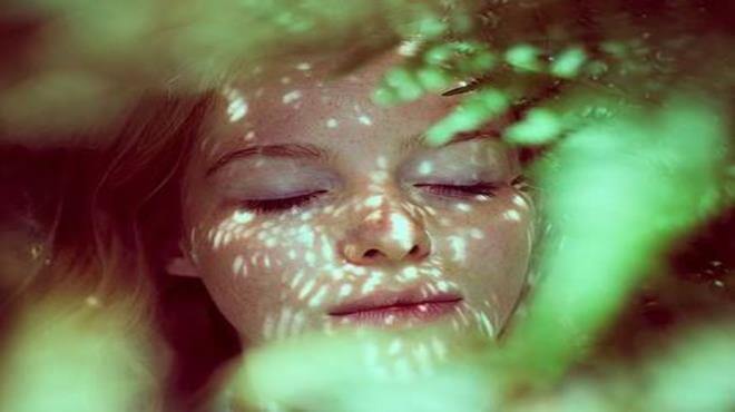 mujer envuelta en helechos