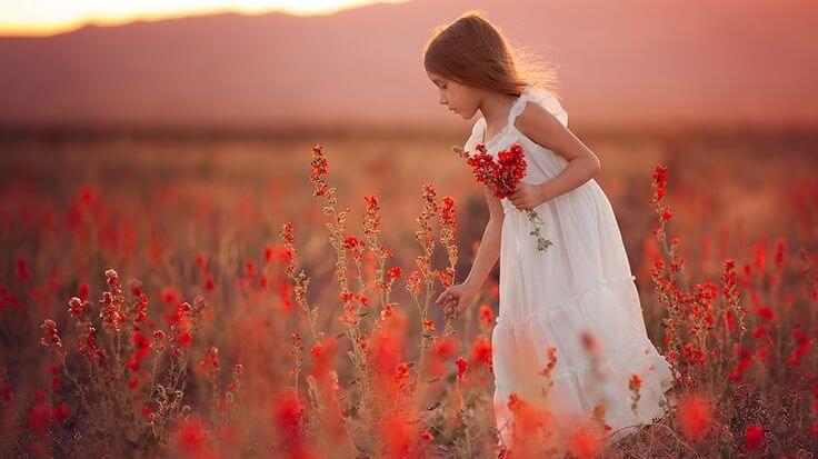 niña en un campo de brezo rojo