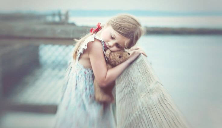 niña abrazada a un oso de peluche