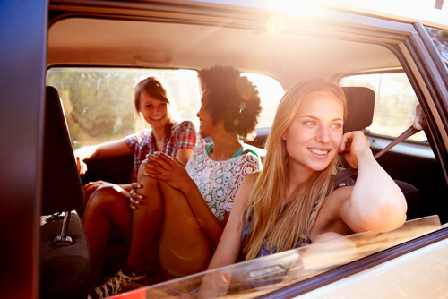 Amigos sentados en un coche de vuelta de sus viajes