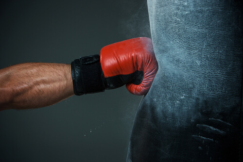 Brazo de hombre golpeando un saco de boxeo