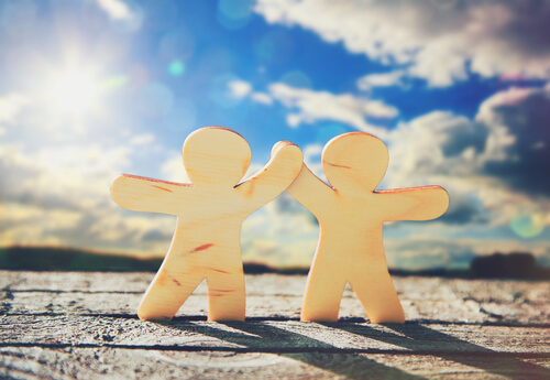 Dos muñecos dándose la mano en símbolo de amistad