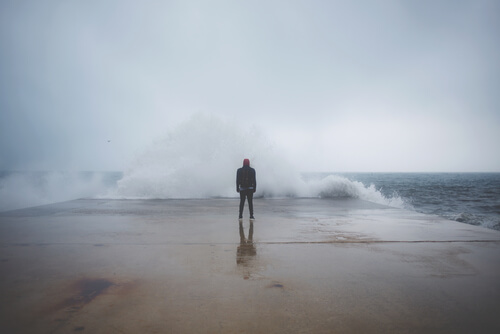 Hombre enfrente del mar sintiendo miedo